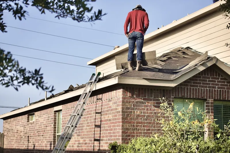 Professional roofer working on a residential roof in Sound Beach